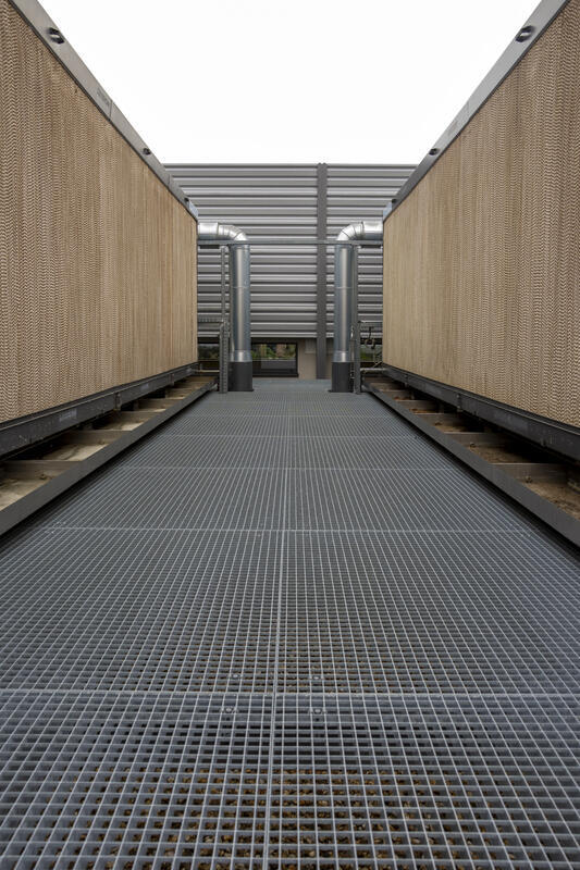 Industriegang aus Gitterrost parallel verlaufenden, mit Metallgittern verkleideten Wänden.